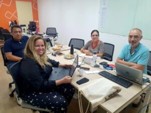 Quatro pessoas em uma mesa de trabalho, profissionais da Escola e Fiocruz Pernambuco