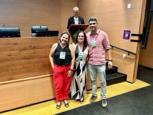 Foto de três pessoas em pé participantes do seminário. Valéria do Polén à esquerda, Carla ao meio e Felipe, da Ensp à direita